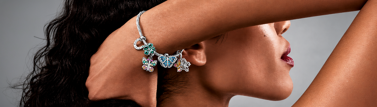 Charm bracelet with butterfly and clover charms